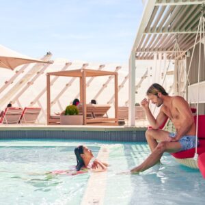 Couple relaxing by the pool on the exclusive Retreat Sundeck of the Celebrity Beyond during a marriage retreat.