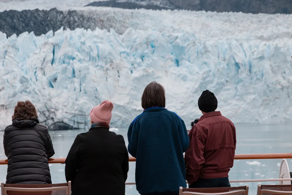 Small group of travelers watching an Alaska glacier from a cruise ship deck