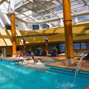 Husbands relaxing inside the Solarium pool area aboard the Celebrity Constellation during a faith-based travel experience.